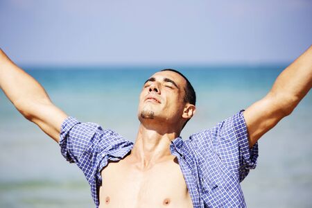 young muscular man posing and standing with outspread hands.の写真素材
