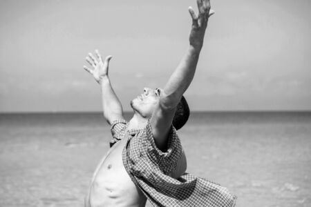 young muscular man posing and standing with outspread hands.の写真素材