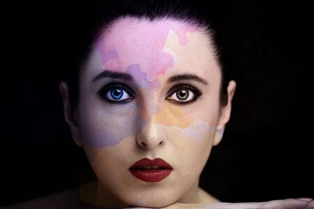 Young attractive woman with long black hair on dark background.の写真素材