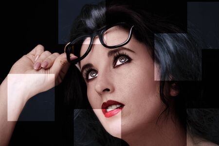 Young attractive woman with long black hair on dark background.の写真素材