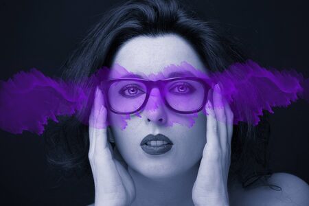 Young attractive woman with long black hair on dark background.の写真素材