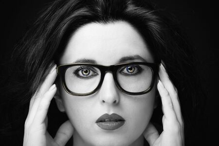 Young attractive woman with long black hair on dark background.の写真素材