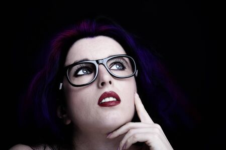 Young attractive woman with long black hair on dark background.の写真素材