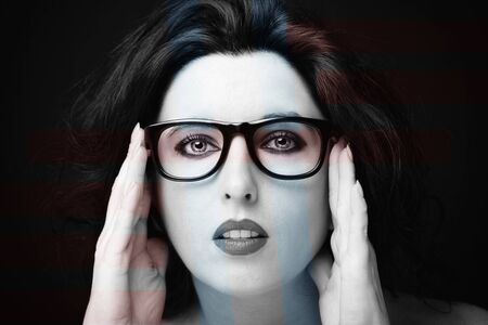 Young attractive woman with long black hair on dark background.の写真素材