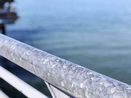 Railing of the pier. The sea coast over blue sky background.の写真素材