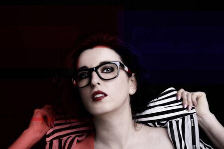 Young attractive woman with long black hair on dark background.の写真素材