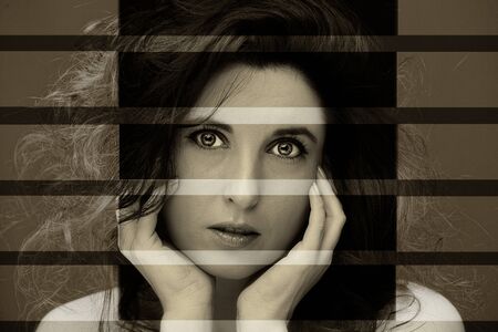 Young attractive woman with long black hair on dark background.の写真素材