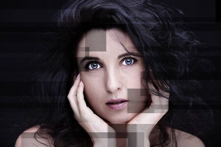 Young attractive woman with long black hair on dark background.の写真素材