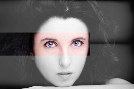 Young attractive woman with long black hair on dark background.の写真素材