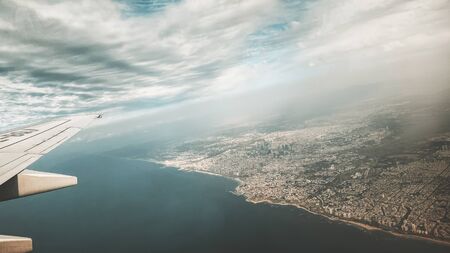Beautiful view through the dirty window in an airplane on the wing and cloudsの写真素材