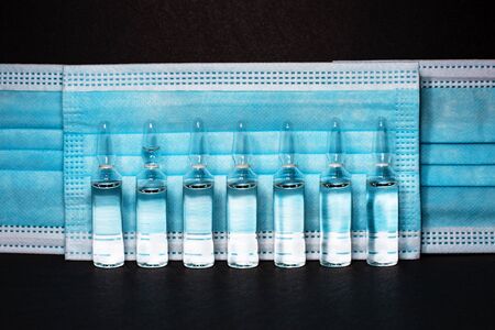 ampoules with medicine on a blue background. coronavirus vaccine, concept medicine vaccination protection covid- 19.の写真素材