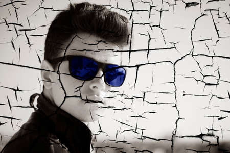 Young attractive man posing in front of camera in a dark  brown jacket on the roof of a residential...