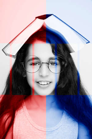 Adorable girl studying with eyeglasses and book on the head on white background