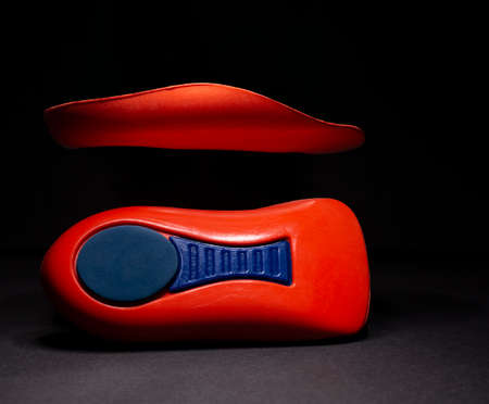 The orthopedic insole on a black background. Treatment and prevention of flat feet and foot...