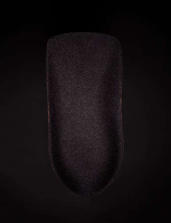 The orthopedic insole on a black background. Treatment and prevention of flat feet and foot diseases. High quality photoの写真素材
