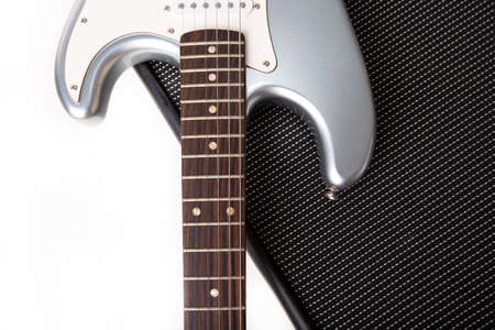 Silver electric guitar on guitar amplifier isolated on white background ..