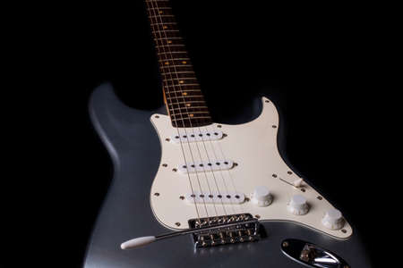 Silver electric guitar isolated on black background.の写真素材