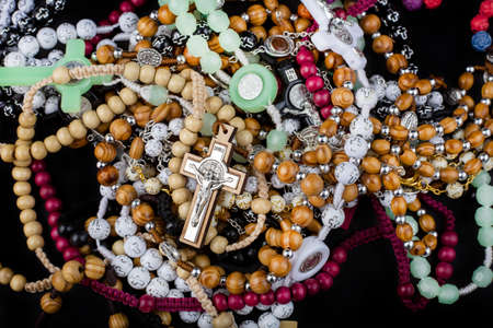 Set of traditional christian holy religious symbol rosary necklace isolated on black backgroundの写真素材