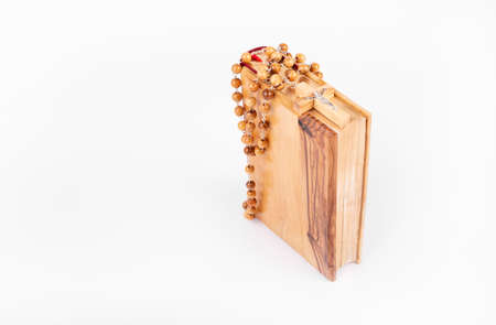 Bible with wooden cross isolated on white background