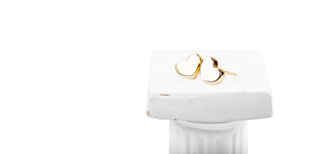 Heart-shaped gold stud earrings on a white background.の写真素材