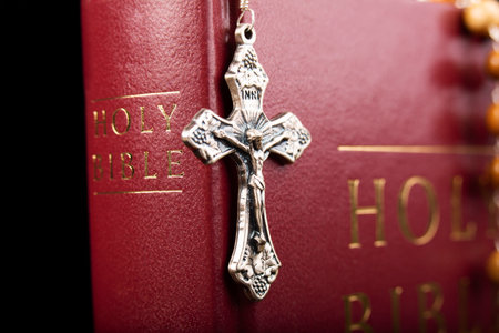 Bible with metal cross isolated on black backgroundの写真素材