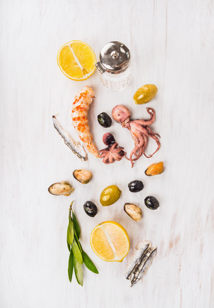 Seafood composing with olives and lemon on white wooden table, top viewの写真素材