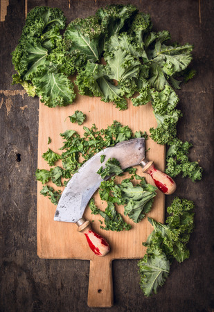 kale on cutting board chopping and mincing knife old, dark wooden background, top viewの写真素材