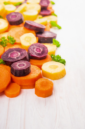 colorful wooden cutting carrots on white background with place for textの写真素材