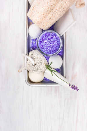 Bath set with lavender, pumice, lotion, salt, bubble balls in gray metal box on white wooden table, spa backgroundの写真素材