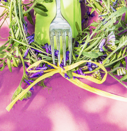 pink summer table decoration with fork and vetch flowers and bowの写真素材