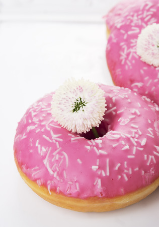 Doughnuts with pink glaze and white flowersの写真素材