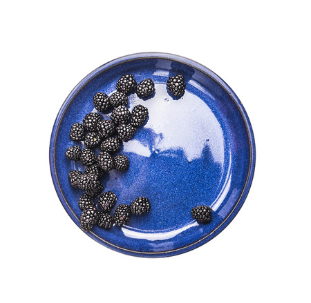 blackberries in blue bowl, top view,  isolated on white backgroundの写真素材