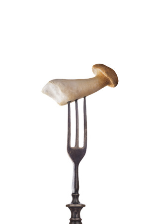Eryngii mushroom on old fork, isolatedの写真素材