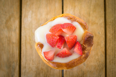 Home mini tart with strawberries and liquid custard on wooden tableの写真素材