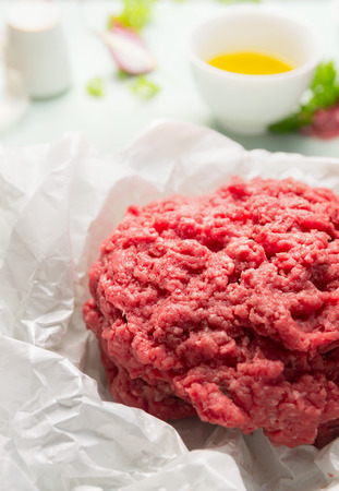 Raw stuffing minced meat on white crumpled paper close upの写真素材
