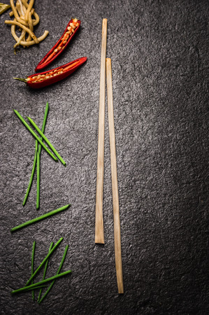 Dark background asian food with chopstick chili noodles and top viewの写真素材