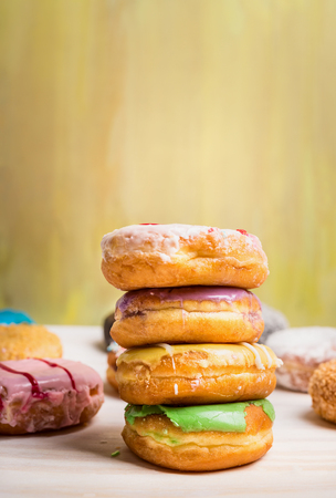 fresh baked  homemade colorful donuts on light wooden backgroundの写真素材