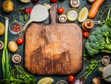 Fresh vegetables and  ingredients for cooking around vintage cutting board on rustic background, top view, place for text.  Vegan food , vegetarian and healthily cooking concept.の写真素材