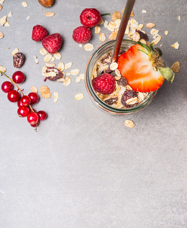 Muesli with oat flakes, dried fruits, nuts and fresh berries. Muesli in glass jar, top view.  Healthy food and Clean Eating conceptの写真素材