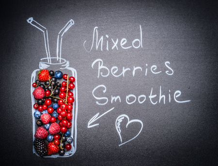 Mixed Berries Smoothie lettering. Various  fresh berries and painted Bottle with drinking straw and heart on blackboard background.の写真素材