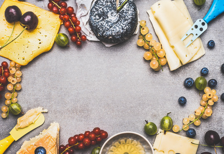 Variety of Delicious cheese with berries and honey for dessert or Breakfast  on rustic background, top view, frameの写真素材