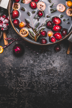 Mulled wine or punch in cooking pot  on dark vintage background, top view, borderの写真素材