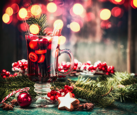 Mulled wine, cookies and holiday decorations on table with bokeh lighting backgroundの写真素材