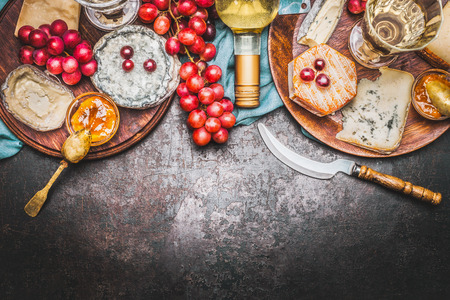 Various Fine cheese selection with Bottle of wine, Honey mustard sauce and grape on rustic background, top view, borderの写真素材