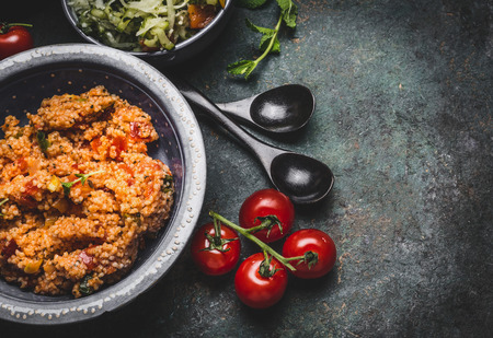 Healthy vegetarian couscous salad in bowl on rustic background, top view, close up, border.  Diet eating, Vegetarian or vegan food conceptの写真素材
