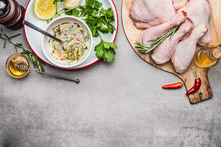 Chicken thighs spices marinating with olive oil, honey , herbs and  lemon, top view, borderの写真素材