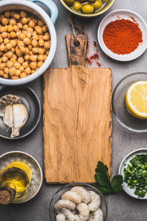 Cooked Chickpeas and various Healthy  ingredients for salad around wooden cutting board, top viewの写真素材