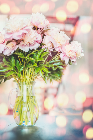 Lovely  pink peonies flowers bunch in vase at sunshine bokeh backgroundの写真素材
