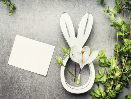 Easter composing with blank white card ,  spring twigs , flowers and bunny decor, top viewの写真素材