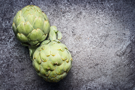 Green Artichokes  on gray concrete background, top view. Superfood conceptの写真素材